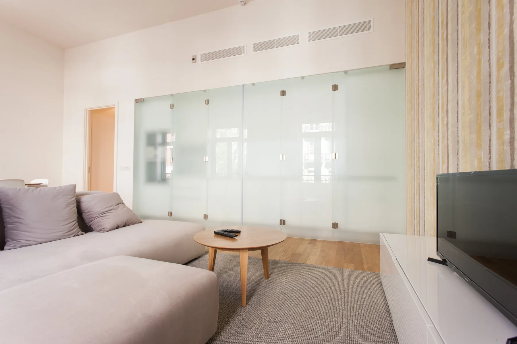 A living room with a sectional seating area, coffee table, and television.