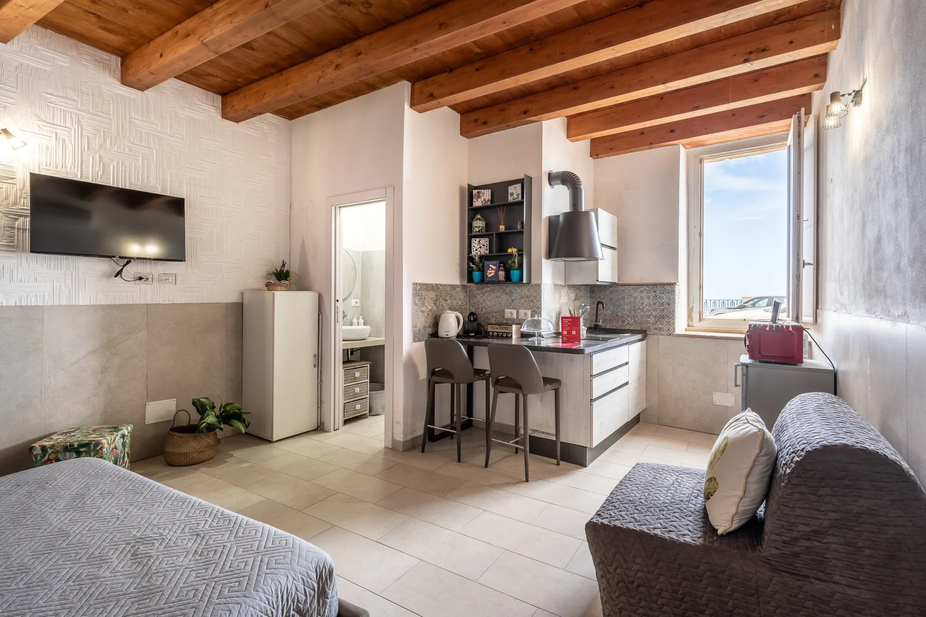 Una luminosa sala tipo estudio con cocina pequeña y zona de estar.