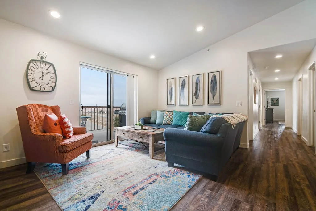 Una sala luminosa con asientos alrededor de una mesa baja junto a una puerta de balcón.