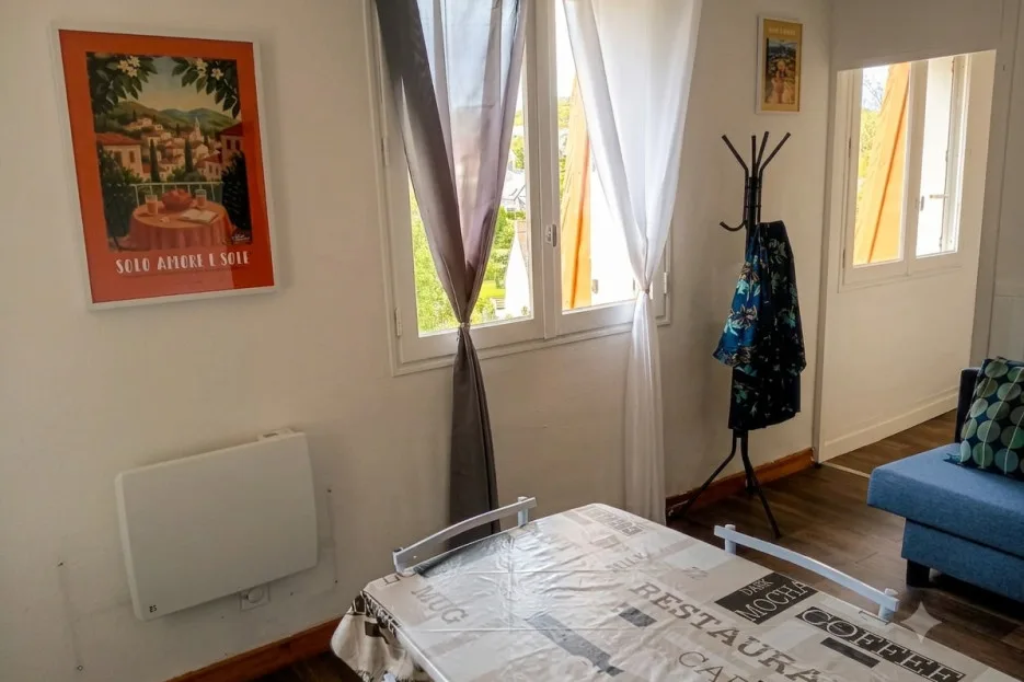 A bright living room with curtained windows and a low table.