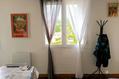 A bright room with a curtained window and a table in the foreground.