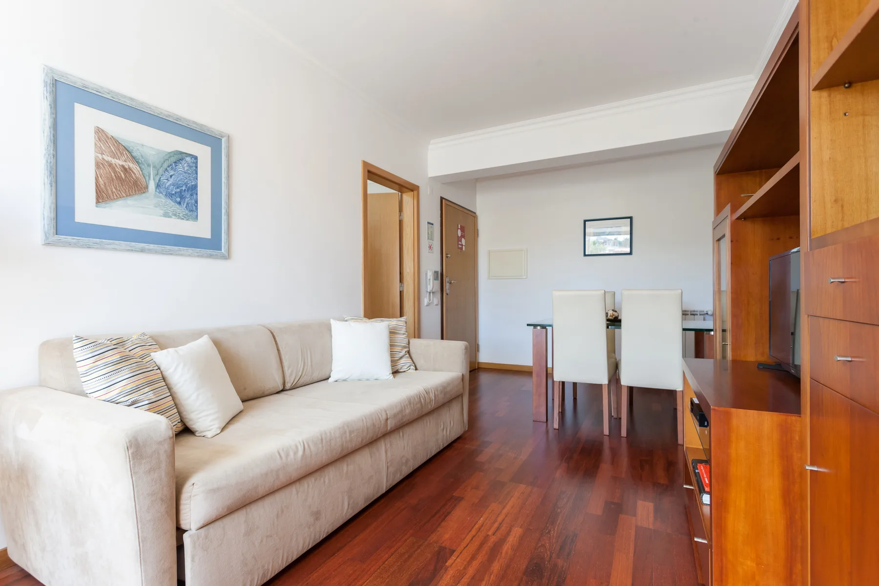 Una sala de estar y comedor con asientos junto a un mueble de almacenamiento de madera.