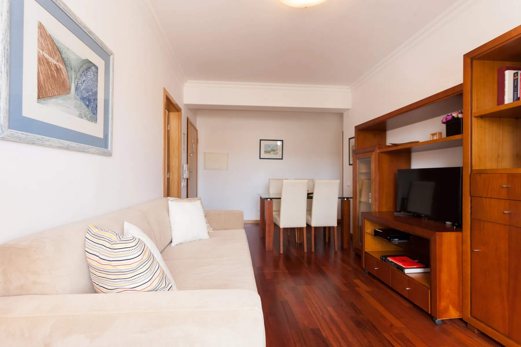 Sala de estar y comedor con asientos, una mesa de comedor y un televisor.