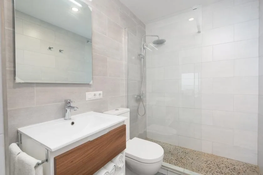 A tiled bathroom with a sink, toilet, and shower.