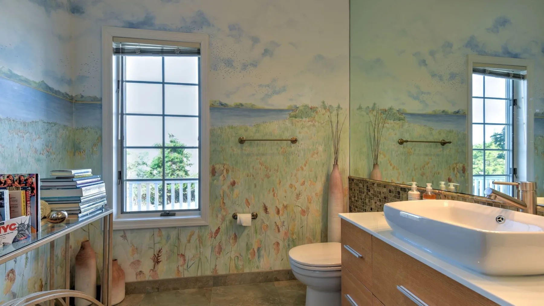 Un baño con bañera, inodoro y ventanas que dan a la vegetación.