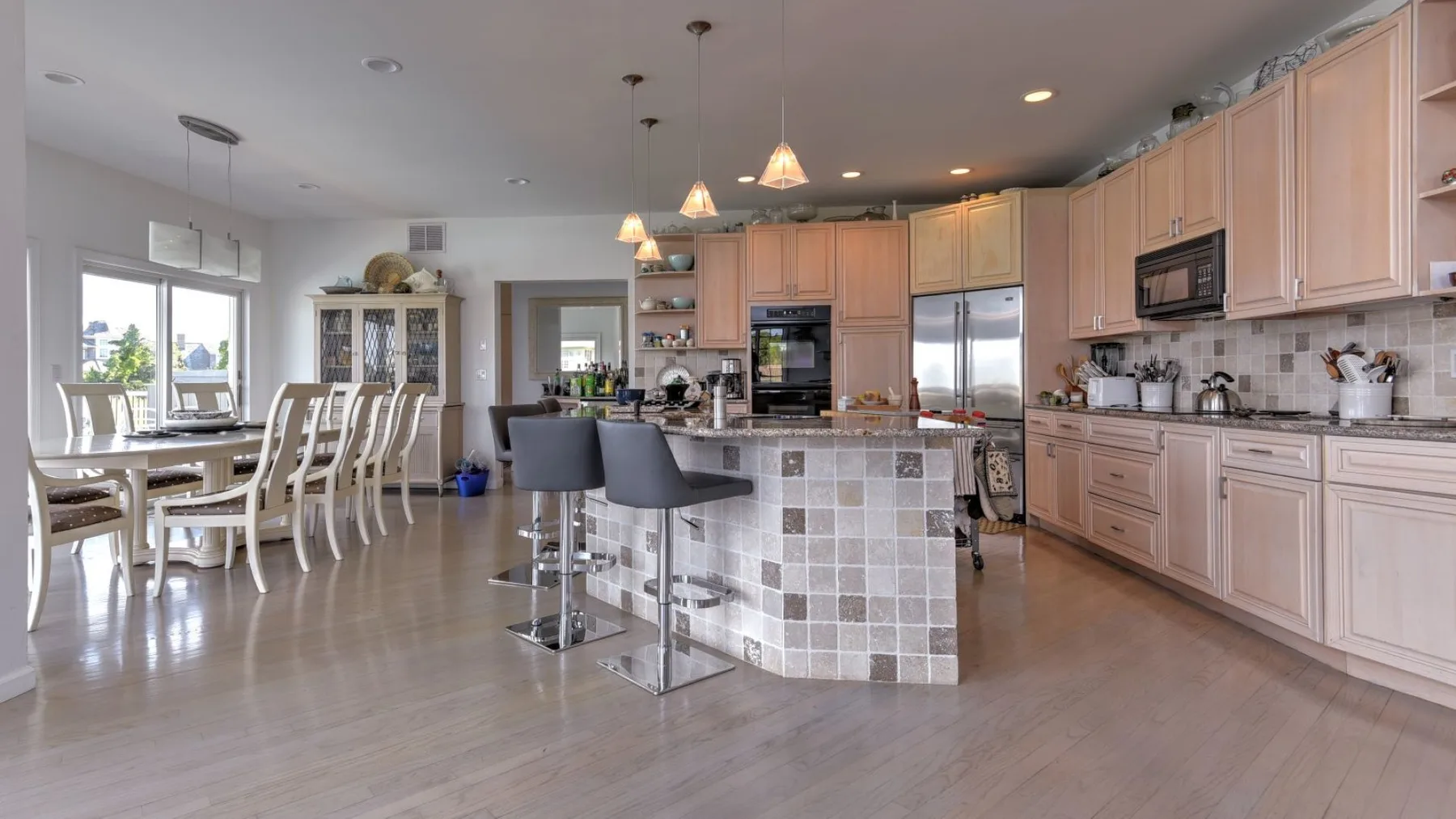 Una amplia cocina y comedor cuentan con una isla grande y una mesa de comedor.