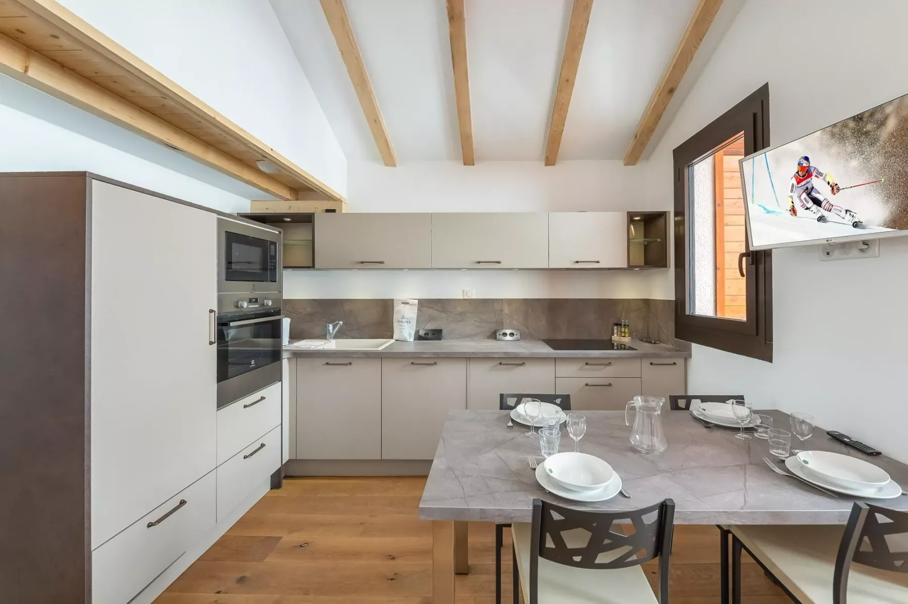 Una cocina moderna y zona de comedor con la mesa preparada para comer.
