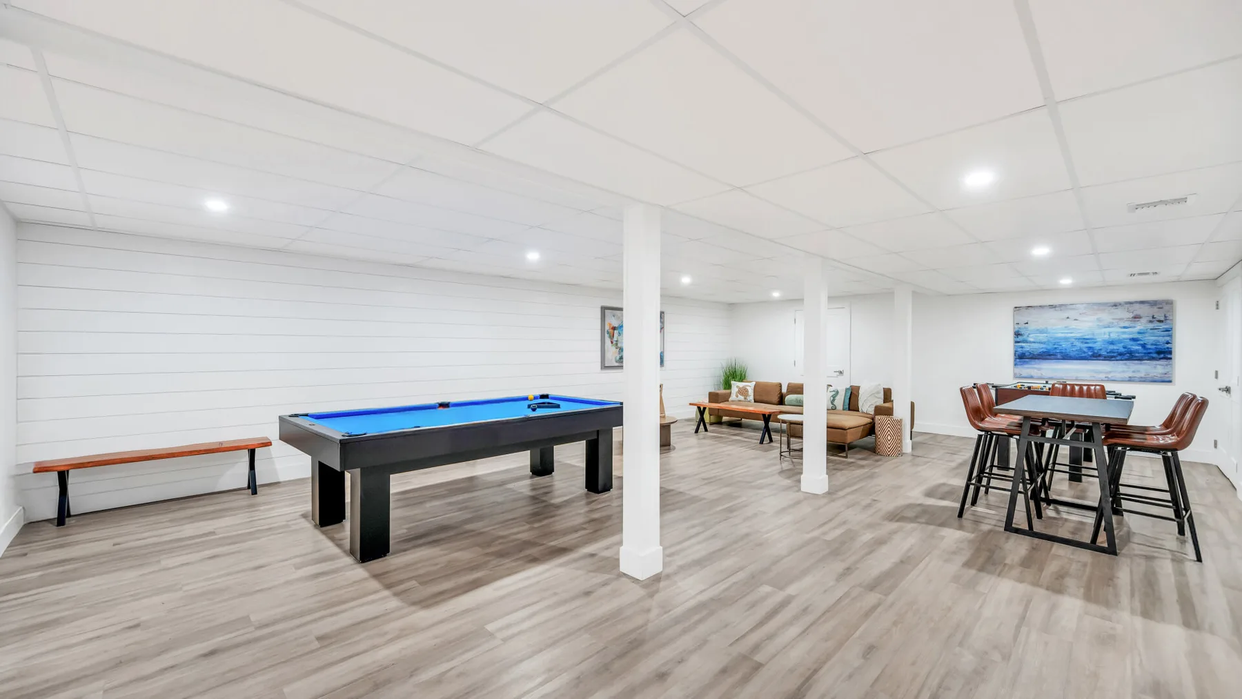 Game room with a pool table, seating, and a dining table.