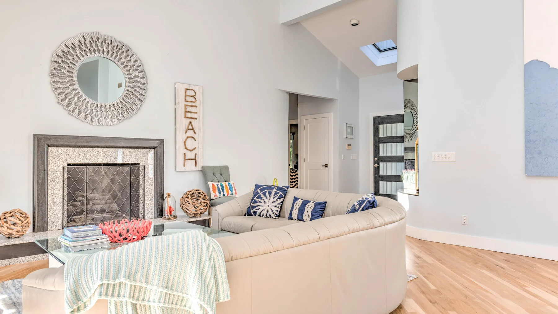 A bright living room features a seating area beside a fireplace.