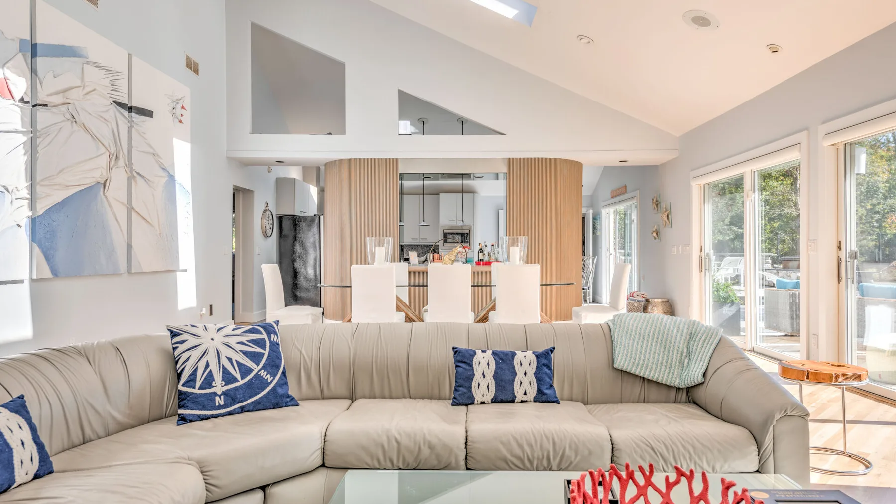 A bright living room with a large sectional sofa and artwork on the wall.