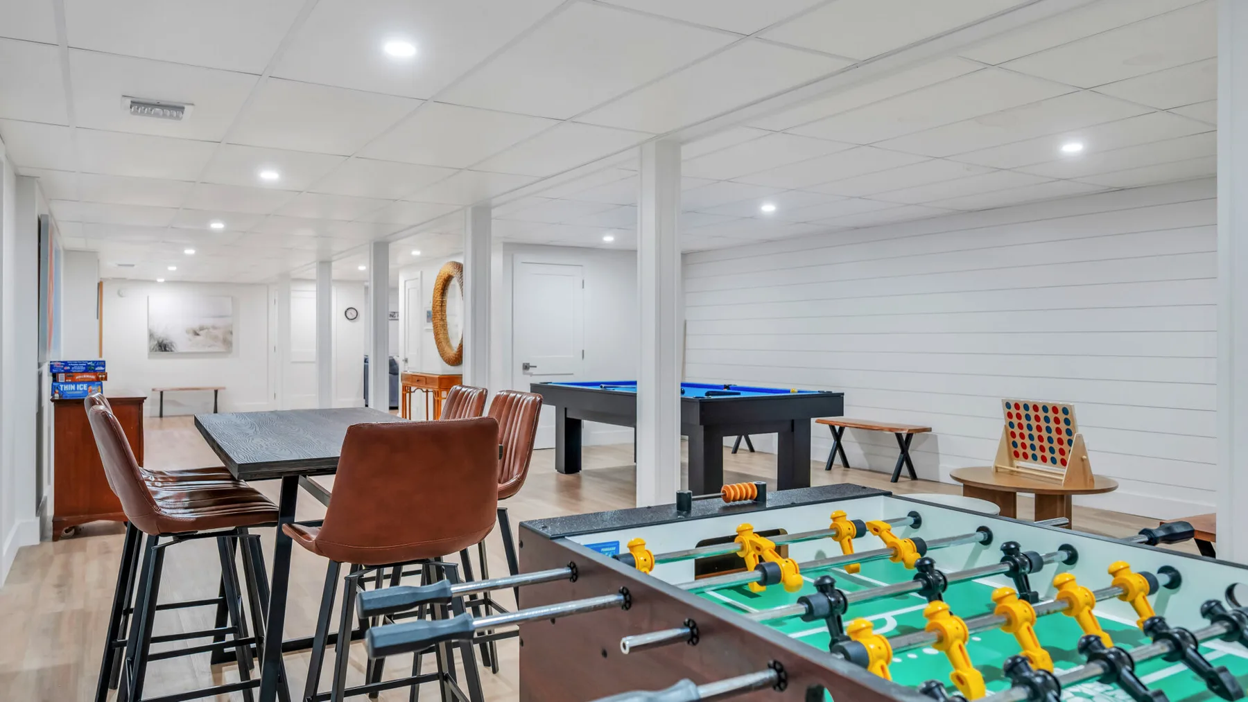 A recreation room with a foosball table and seating.