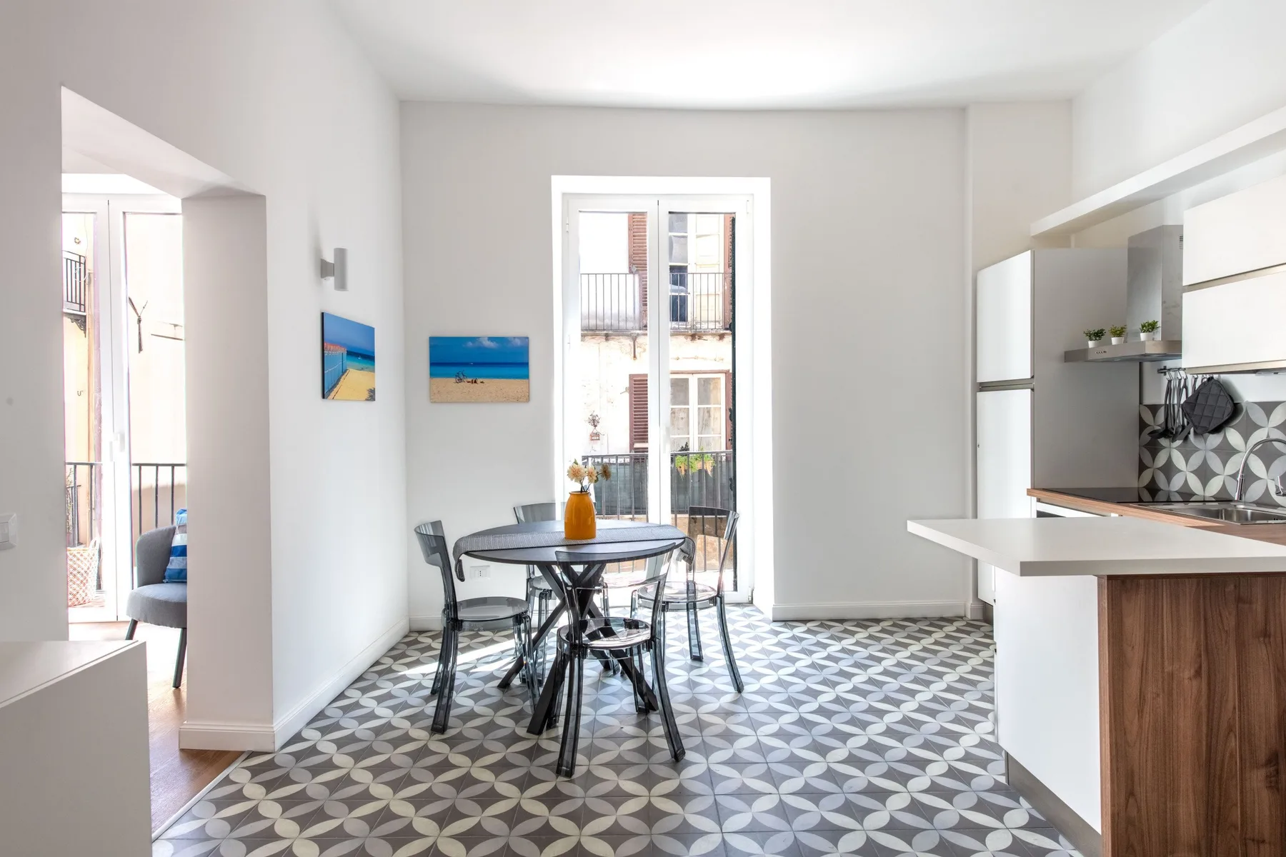A bright dining area with a table beside a compact kitchen.