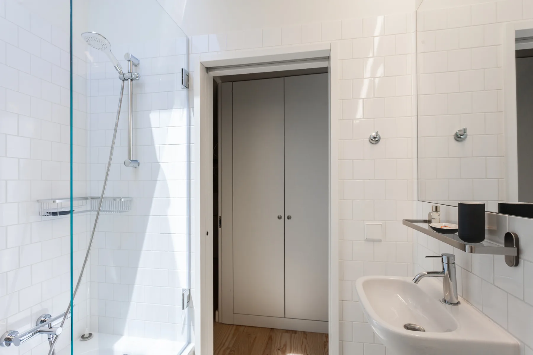 A tiled bathroom with a shower and sink.