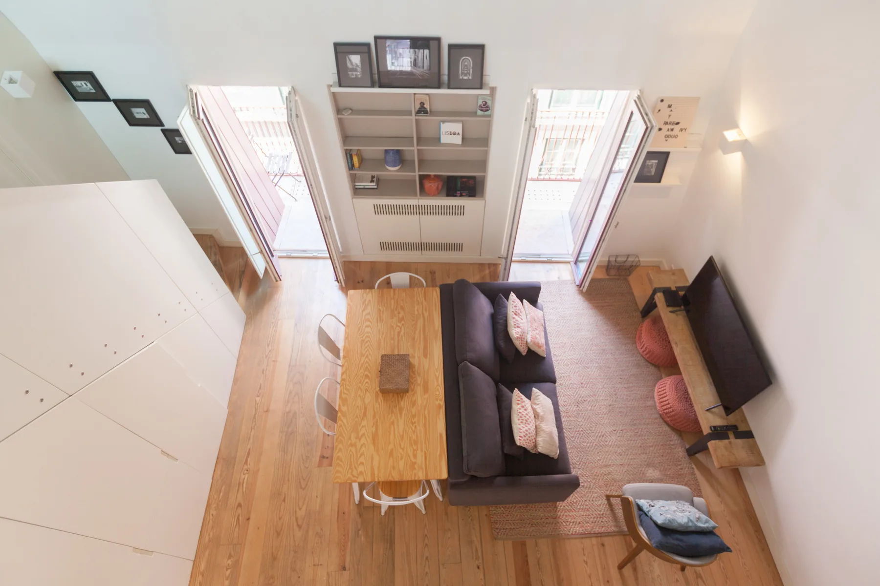 A living room with a dark sofa, coffee table, and wall-mounted television.