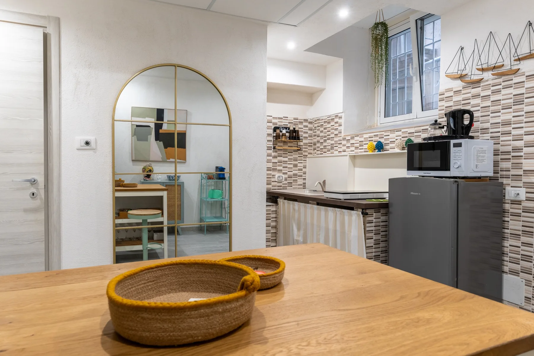 Una cocina luminosa con una mesa de madera, una encimera y un salpicadero de azulejos.