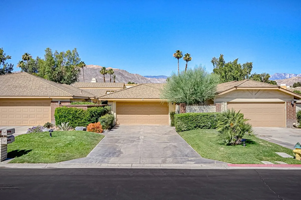 A row of single-story homes with driveways and landscaped front yards.