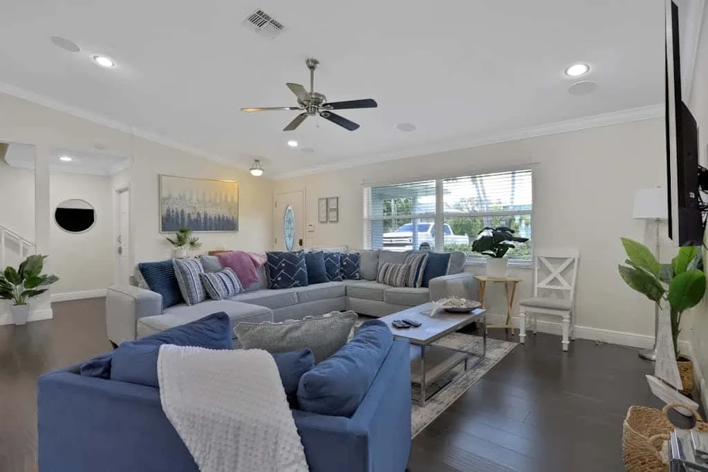 A bright living room with blue seating arranged around a low coffee table.