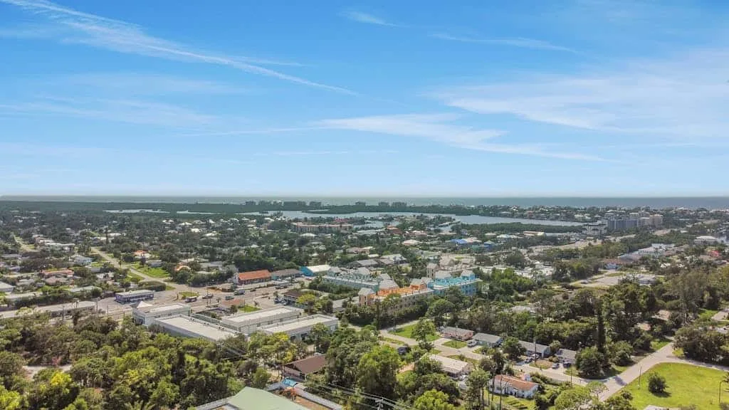 Aerial view of a neighborhood with a broad waterway in the distance.
