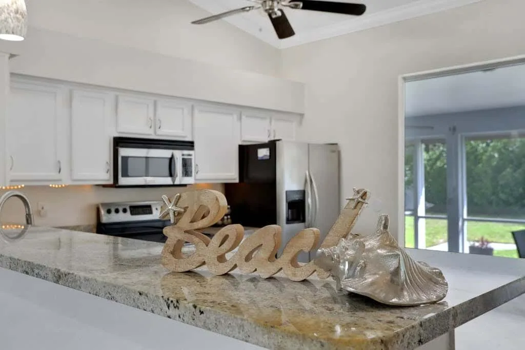 A bright kitchen with white cabinets and a large island.