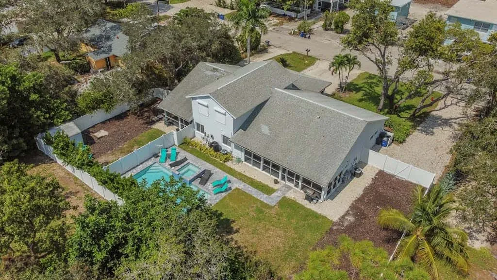 An aerial view of a house with a swimming pool in the yard.