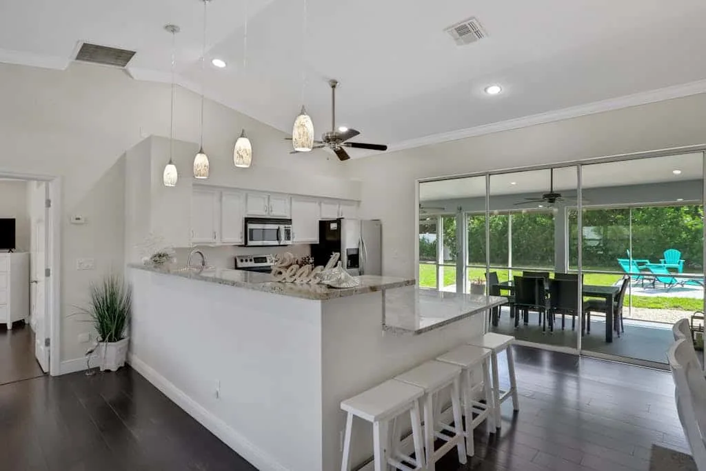 An open-plan kitchen and dining area with large glass doors opening onto a patio.