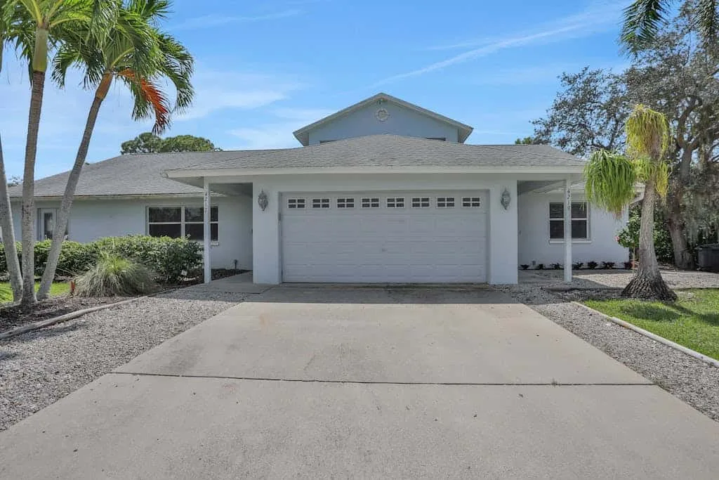 A single-story house with a wide driveway leading to a closed garage.