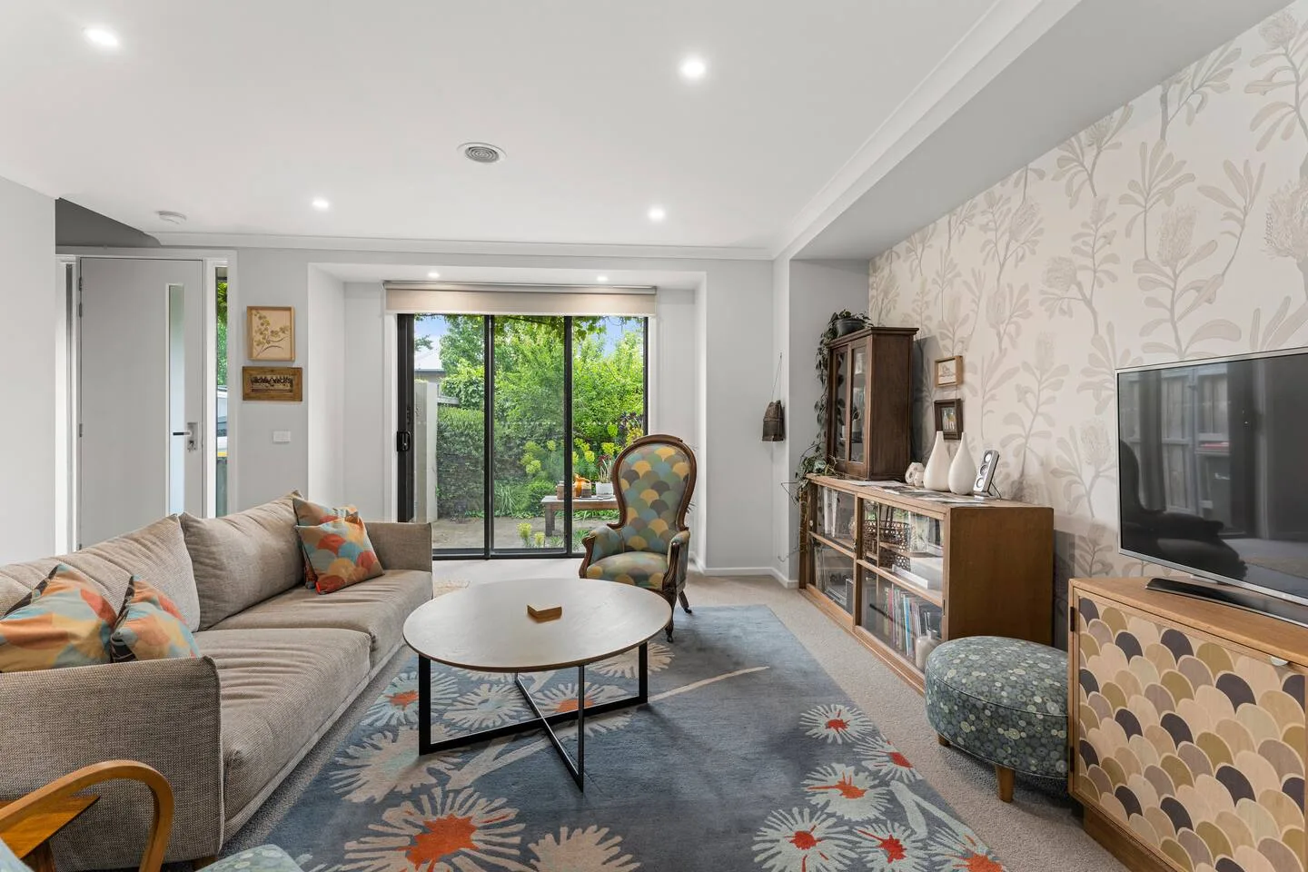 La sala de estar ofrece un refugio tranquilo con texturas estampadas, una combinación de muebles y vistas a las copas de los árboles que invitan a conversar relajadamente y disfrutar de momentos de descanso.