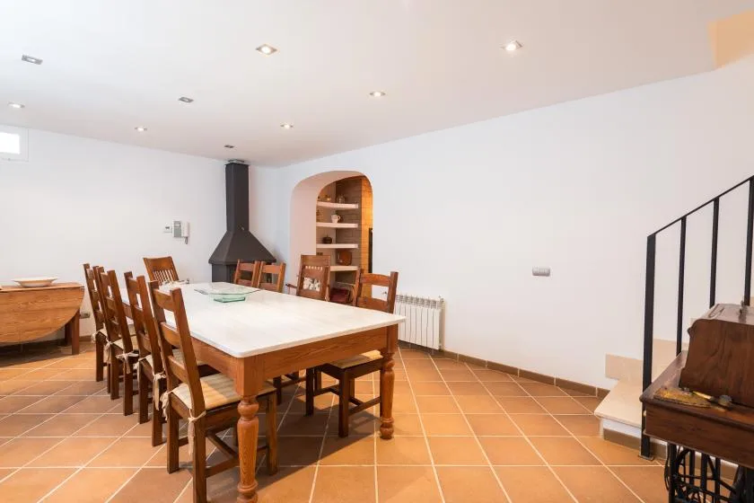 Comedor con una mesa larga y asientos de madera.