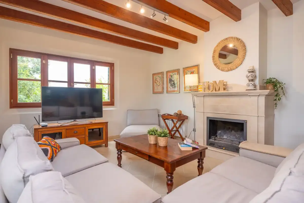 Una sala de estar luminosa con asientos, una mesa de centro y una chimenea.