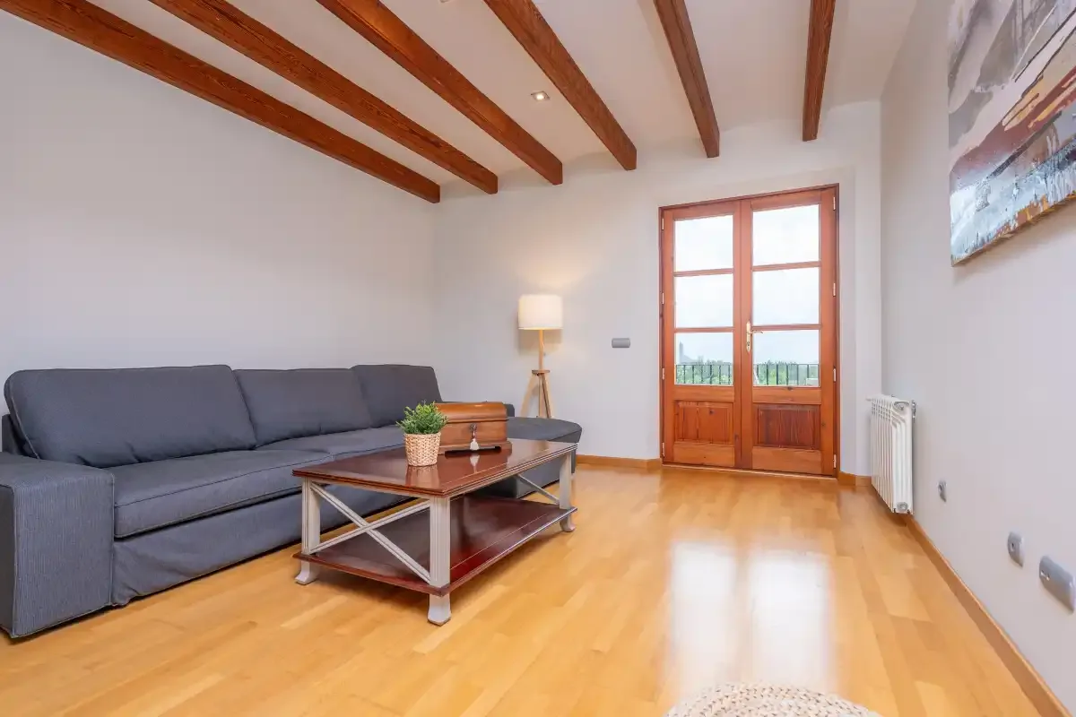 Una sala de estar luminosa con asientos y una mesa de centro de madera.