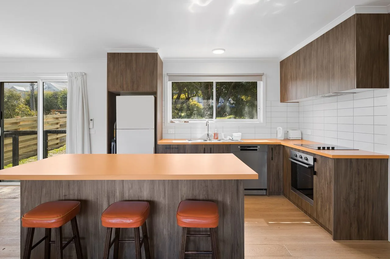 Una cocina moderna con una isla central y gabinetes de madera.