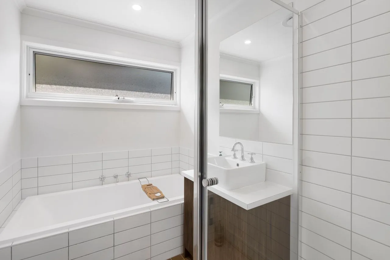 Un baño luminoso con bañera y lavabo.