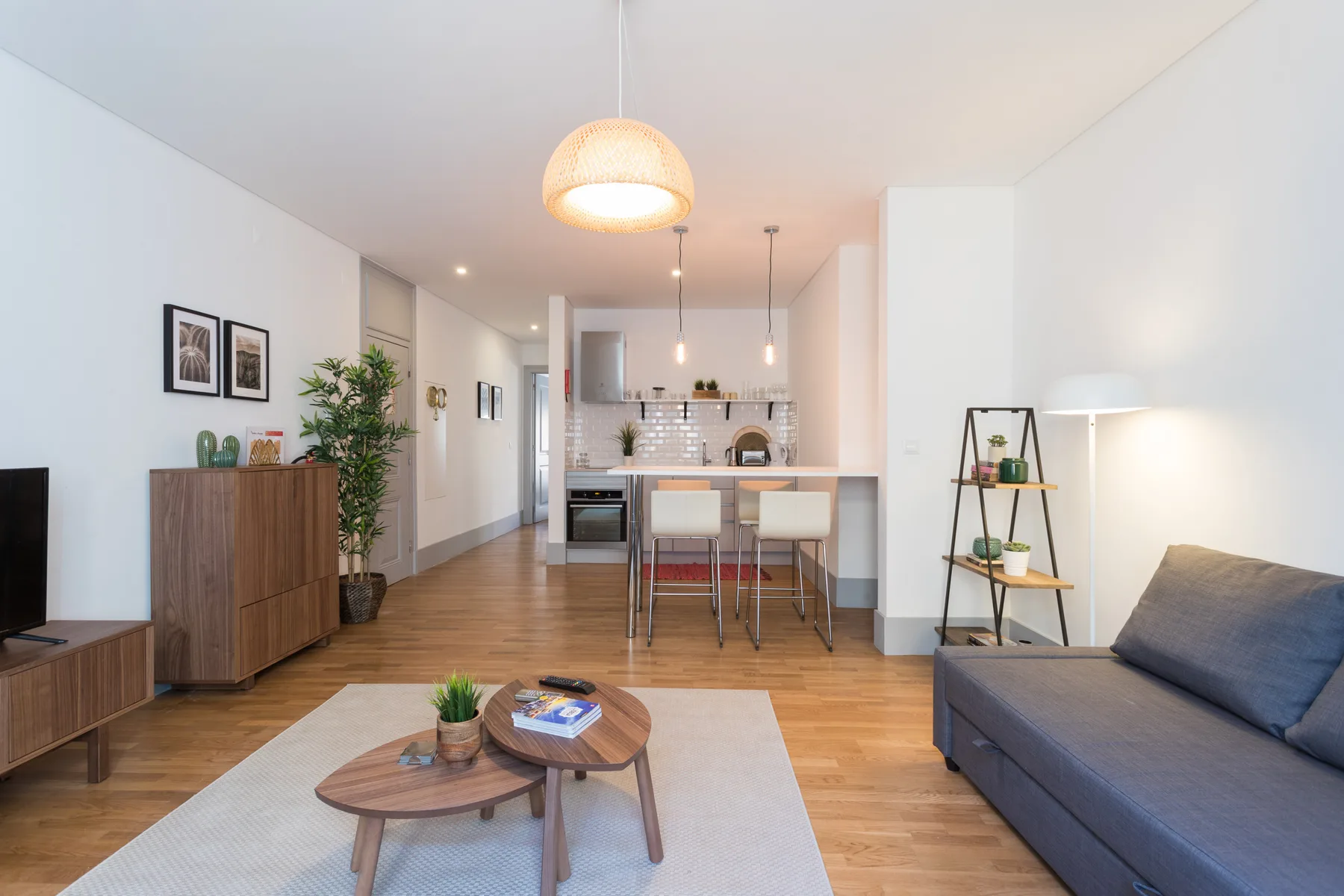 Sala de estar con asientos, una mesa de centro y cocina abierta.