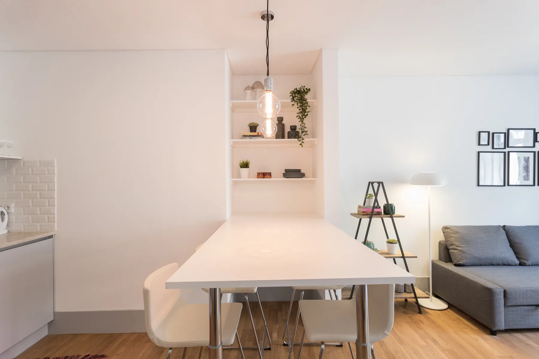 Un comedor luminoso con una mesa larga y asientos grises.