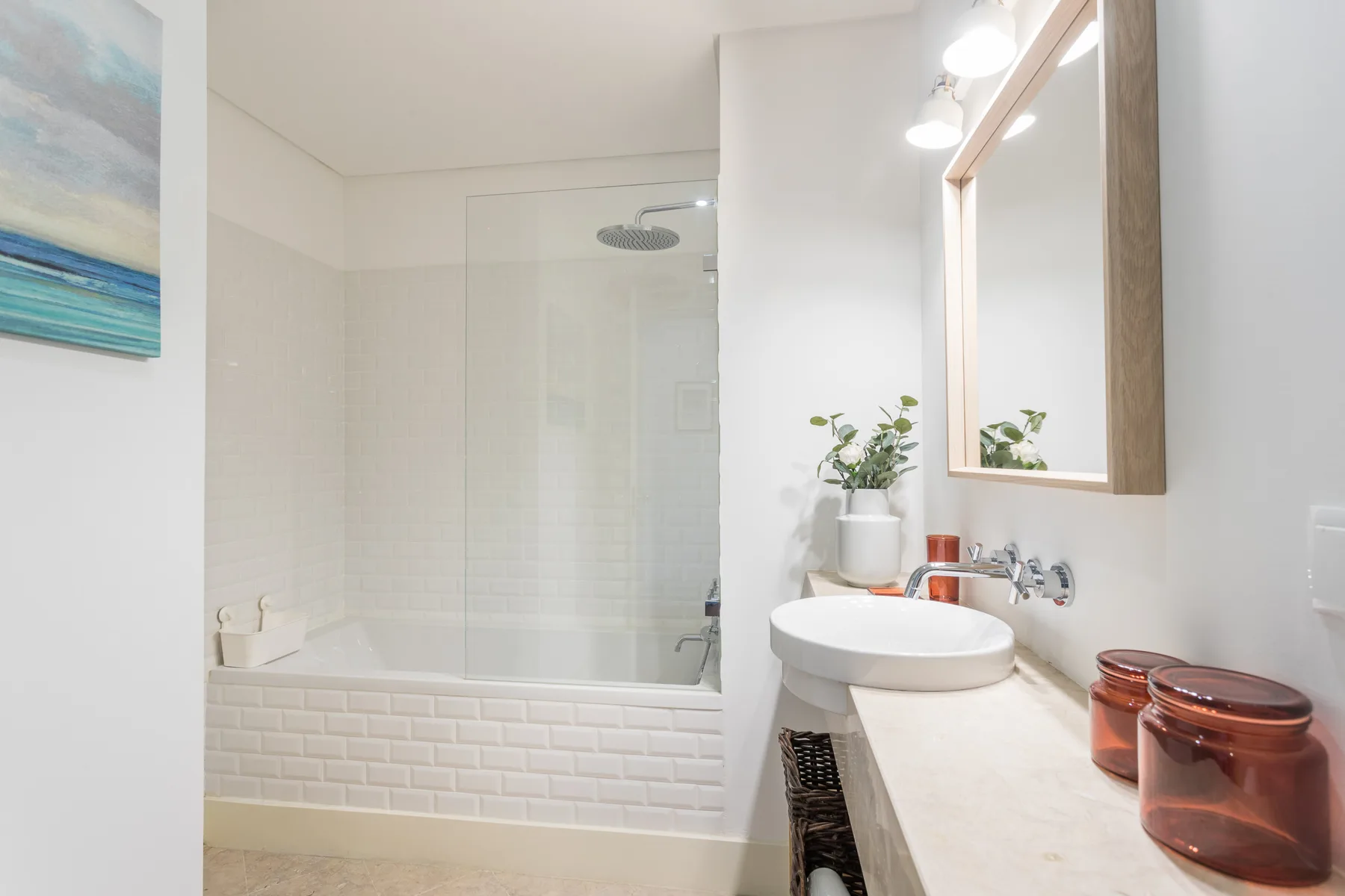 Un baño luminoso con bañera, lavabo y espejo de pared.