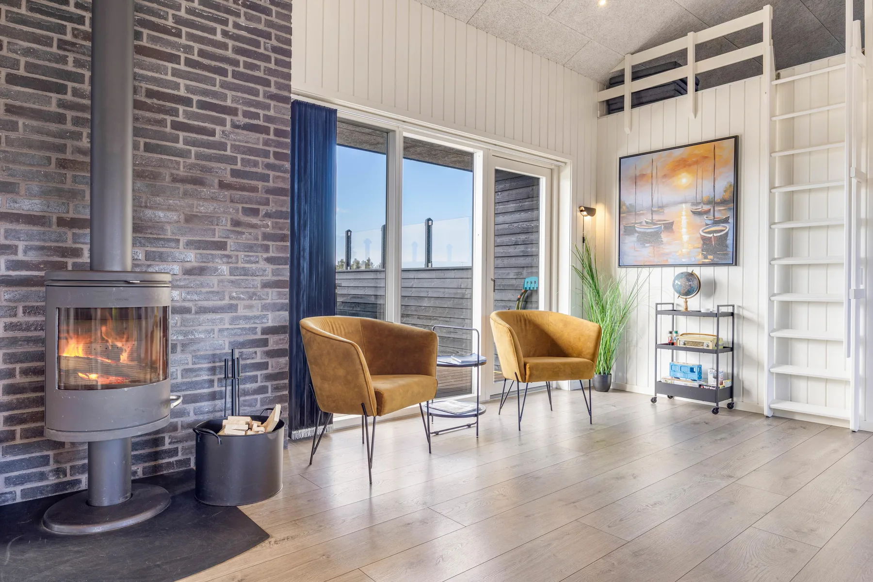 Una sala luminosa con una chimenea independiente y dos sillones.