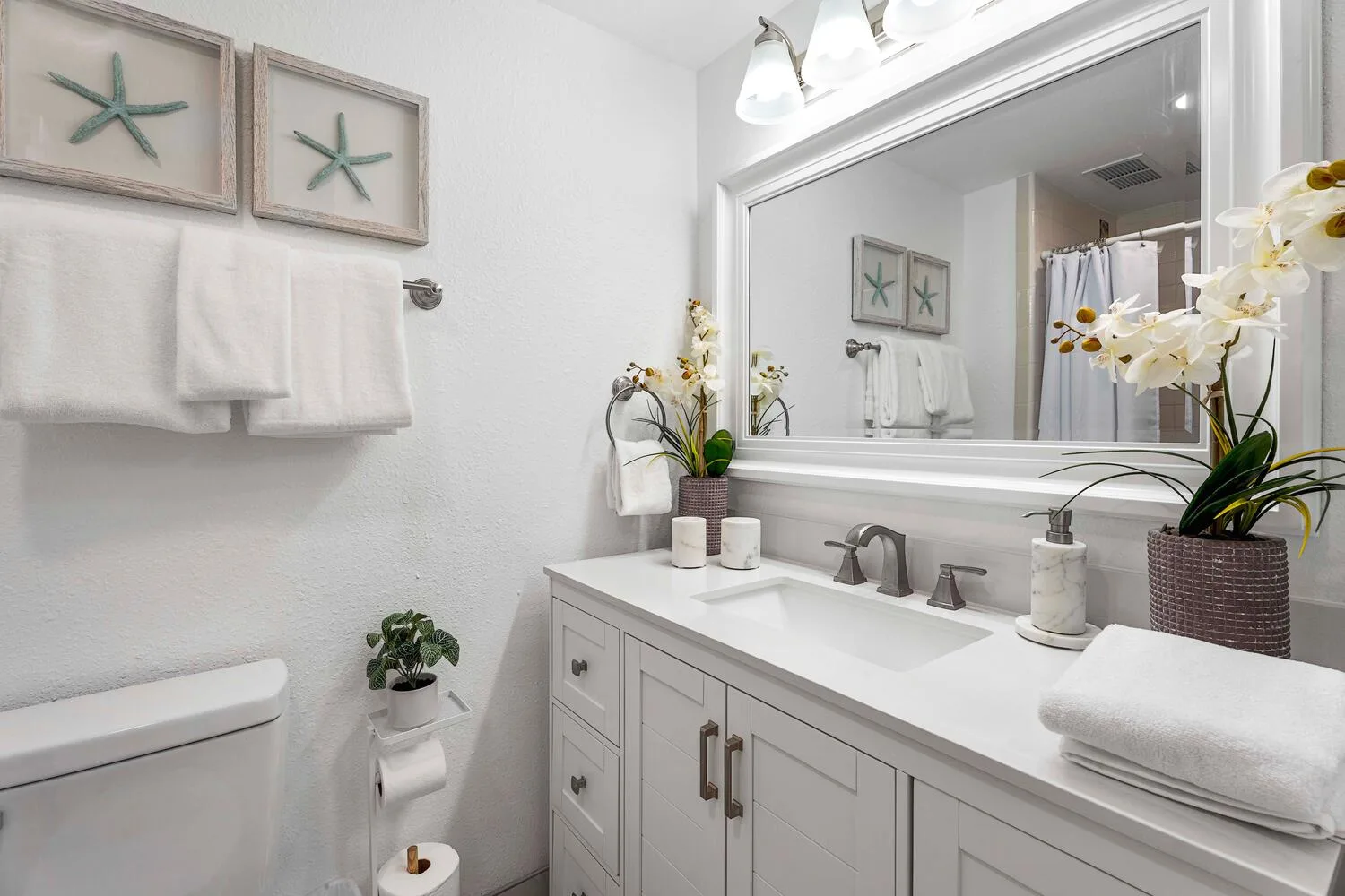 Un baño luminoso con un mueble de lavabo largo y un espejo grande.