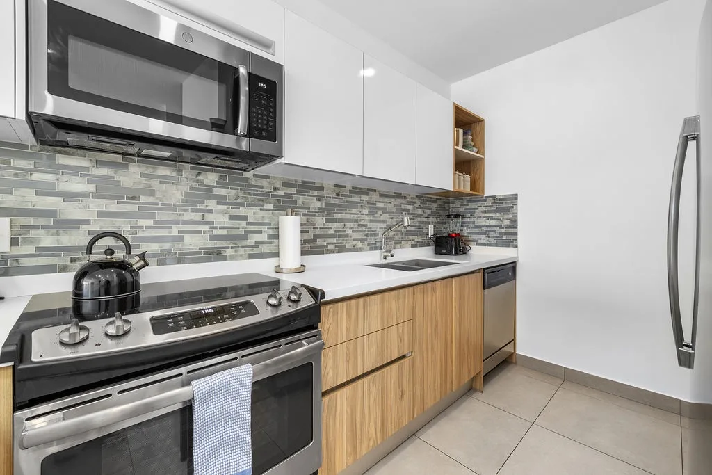 Your modern kitchen awaits with sleek stainless steel appliances, stylish tile backsplash, and ample counter space for preparing meals during your stay.