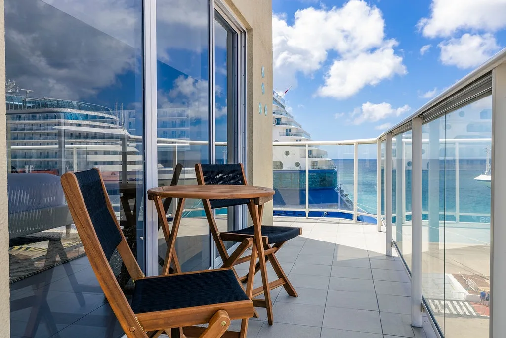 Your private balcony overlooks turquoise waters and features cozy seating perfect for morning coffee or evening relaxation with stunning ocean views.