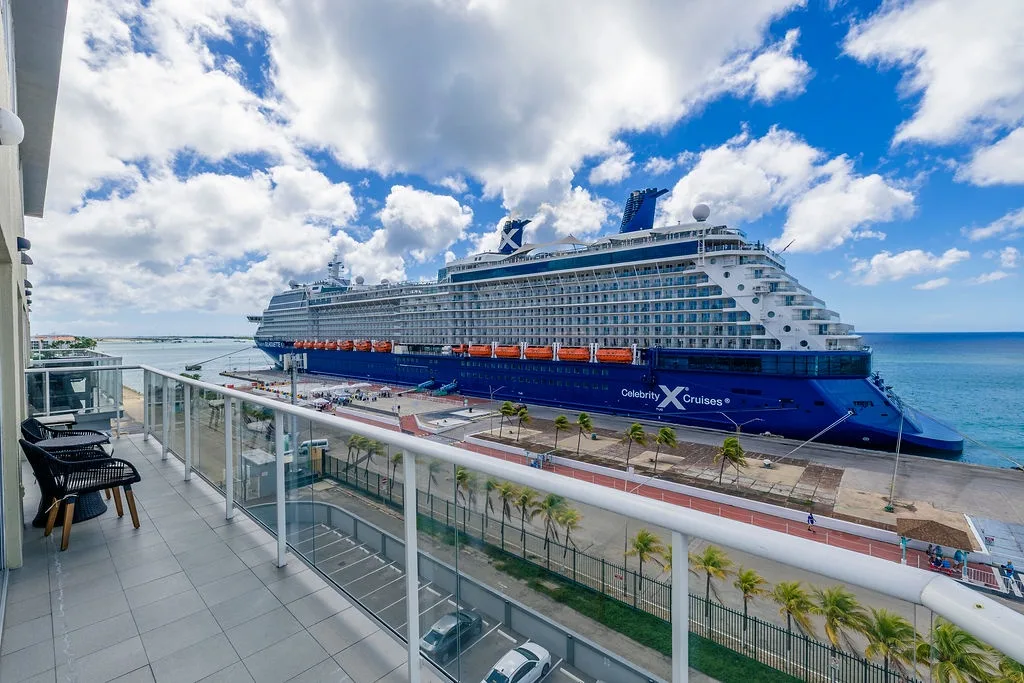 Waterfront property located near cruise terminal, offering balcony views of palm-lined docks and turquoise Caribbean waters.