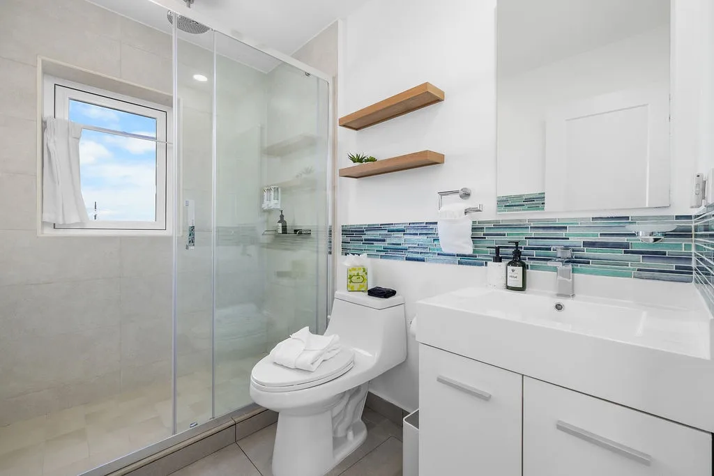 Refresh in your bright, modern bathroom with coastal-inspired tile, a spacious walk-in shower, and thoughtful storage to keep everything you need within reach.