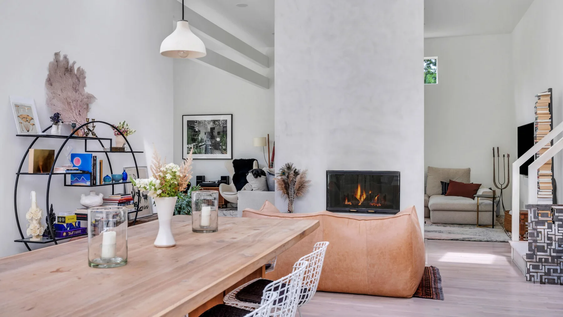 Una sala de estar moderna con una mesa de madera, asientos y una chimenea.