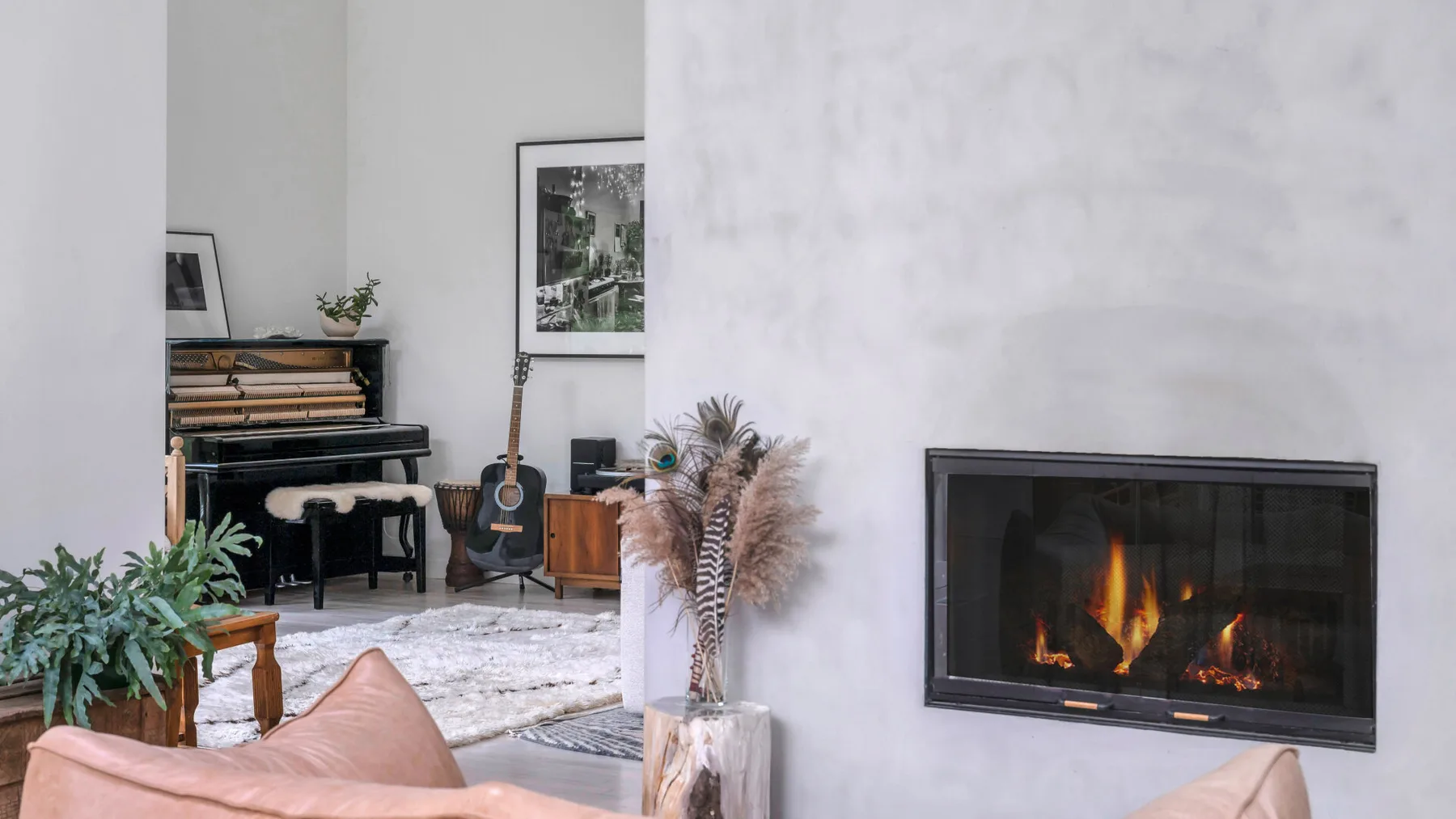 Una sala de estar con chimenea, piano y asientos.