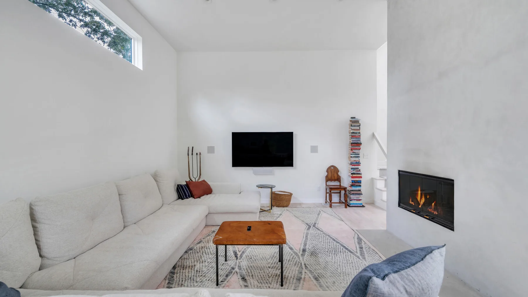 Una sala luminosa con asientos, una mesa de centro y una chimenea encendida.