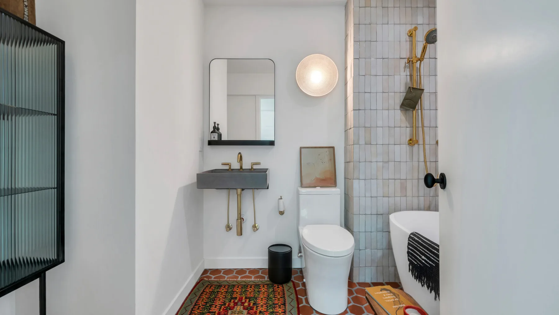Un baño con lavabo, inodoro y zona de ducha con azulejos.