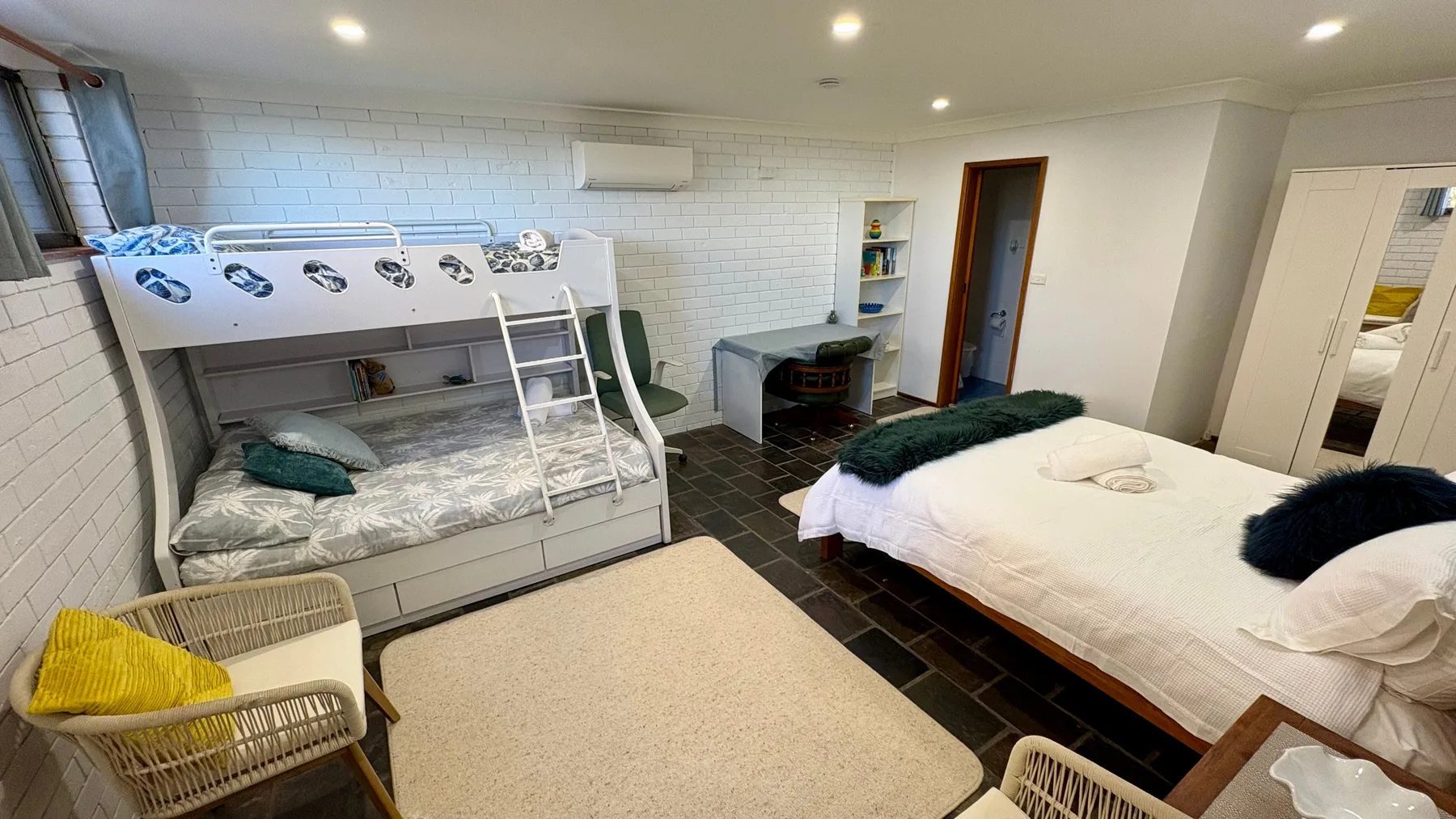 Un dormitorio con literas y una cama grande.