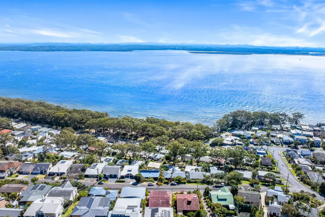 Vista aérea de un barrio costero junto a una amplia bahía.