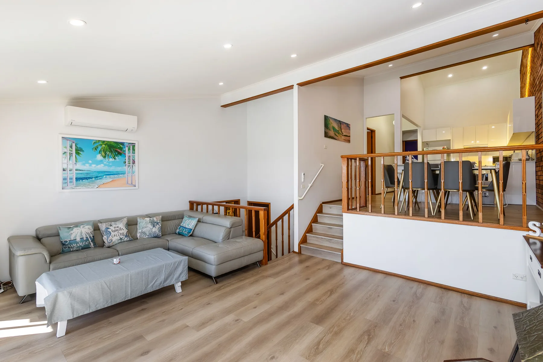 Una sala de estar luminosa con asientos junto a un comedor elevado.