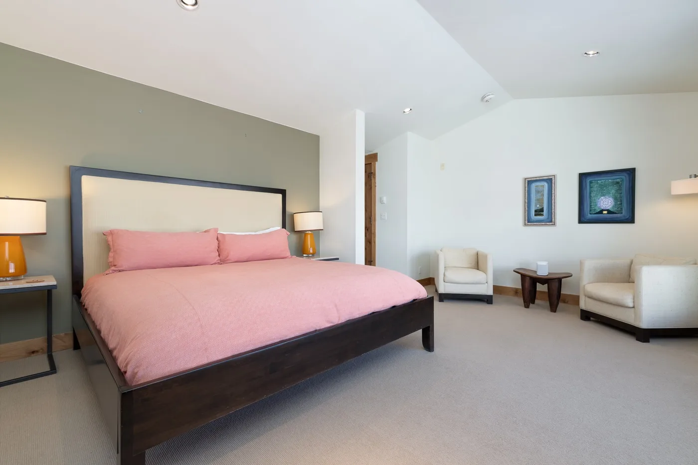 A bedroom with a large bed and seating area.