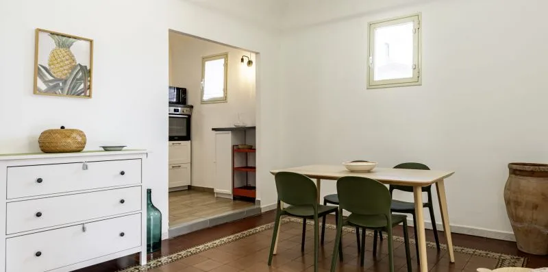 Un comedor con una mesa y sillas junto a una cocina abierta.